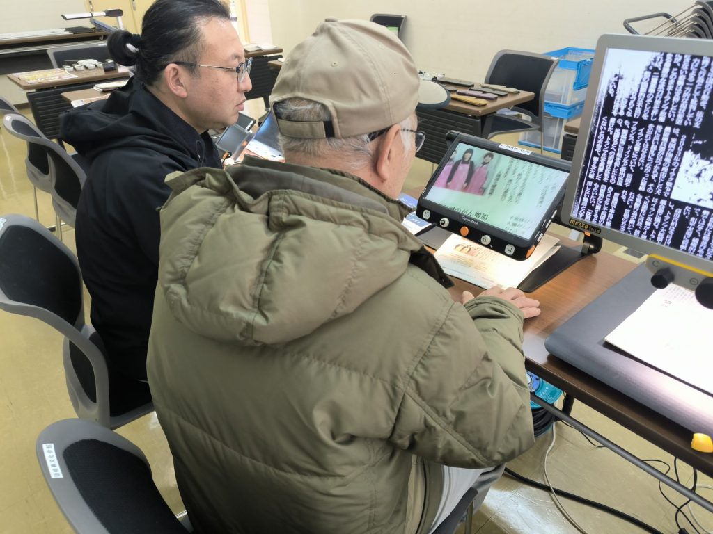 拡大読書器を体験する来場者